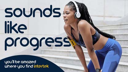 A woman in workout clothes and wearing headphones taking a break from exercising